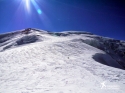 Reviewing the ski run, looking up from the summit of Aiguille du Goûter to Dome du Goûter